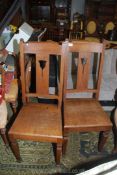 A pair of Oak hall Chairs having solid seats,