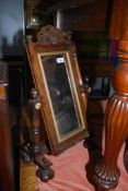 A darkwood framed Swing mirror with carved finial and gilt detail, 27'' tall.