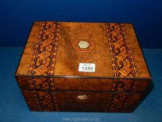 A parquetry jewellery box with interior shelf and fitted compartments with blue fabric lids,