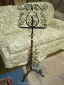 A wrought iron metal music stand with copper column, 49'' tall overall.