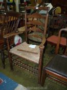 A late 19th c. Oak and rush Lancashire Armchair with ladder back bobbin turned detail.