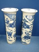 A pair of oriental tubular vases with raised figures of Warriors on crazed ground,