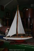 A model sailing Yacht on a wooden plinth, 31" long x 47" tall overall.
