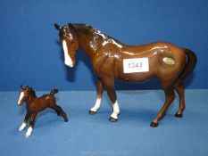 A Beswick horse in brown with two white socks and a white stripe to bridge of the nose- leg broken