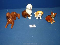 Four dog figurines to include a Goebel West German brown and white sheep dog and a boxer puppy,
