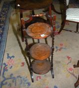 An oak three tier folding Cakestand having mirrored twist supports, 34 1/2'' high.