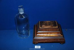 An unusual wooden box/clock stand made of mixed woods and an old ink bottle with stopper.