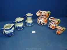 Three graduated Ironstone china jugs in Imari style pattern with green snake handle and three blue