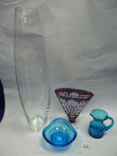 A tall glass vase, a fan shaped vase, and two pieces of blue glass - jug and dish.