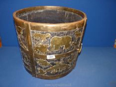 A heavy rustic wooden log bucket with brass banding and brass applied animals within panels,