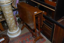 A Mahogany Sutherland Table standing on turned legs, 24'' x 6 1/4'' extending to 23 1/4''.