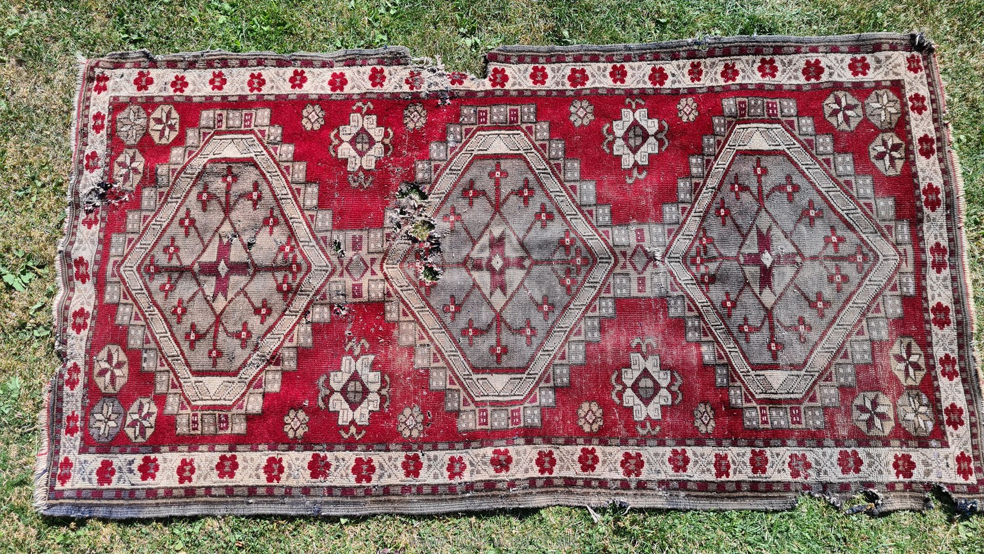 A red ground Eastern Shabby Chic rug with 3 guls and floral border, poor condition, a/f., approx.