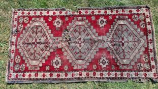 A red ground Eastern Shabby Chic rug with 3 guls and floral border, poor condition, a/f., approx.