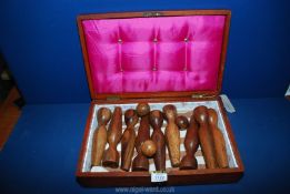 A Box with central brass shield plaque, containing vintage wood skittles and balls,