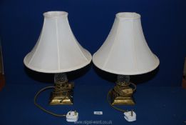 A pair of Lamps with glass and brass base, having cream shades, 18" tall.