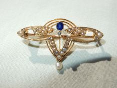 A 15ct Art Nouveau style brooch with seed pearls and blue stone sapphire (?) in leather box.