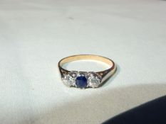 A 9ct gold lady's ring set with a small central sapphire and a pair of small diamonds (3 medium