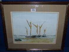 A framed and mounted watercolour depicting moored boats at low tide, signed lower right 'C. Heames'.