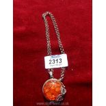 A silver necklace with amber style silver pendant.