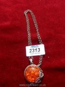 A silver necklace with amber style silver pendant.