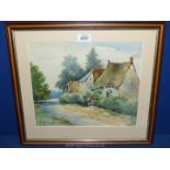 A framed and mounted watercolour depicting cottages and two ladies talking over a garden gate,