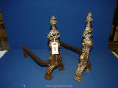 A pair of brass and metal fire dogs, 15" high x 13½" deep x 7" wide.