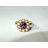 A lady's 18ct gold ring set with a central oval amethyst surrounded by 10 seed pearls,