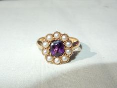 A lady's 18ct gold ring set with a central oval amethyst surrounded by 10 seed pearls,