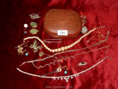 A terracotta coloured jewellery case containing a quantity of costume jewellery including necklace,