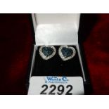 A pair of sterling silver, blue and white diamond earrings.