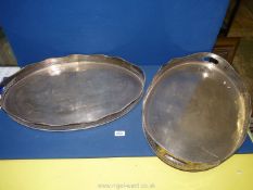 Two large plated serving trays with pierced wavy edge sides and standing on small feet.