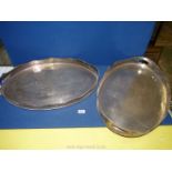 Two large plated serving trays with pierced wavy edge sides and standing on small feet.