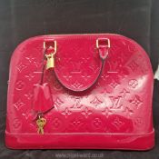 Louis Vuitton: a red patent leather 'Alma' Handbag with zip fastening to the bag;