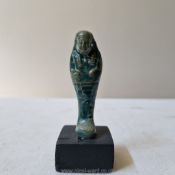 A small ancient Egyptian blue faience ushabti figure mounted on stand, late period or Ptolemaic, c.