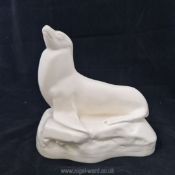 A Wedgwood white glazed figure of a seal by John Skeaping, 8 1/2'' x 8 1/2''.