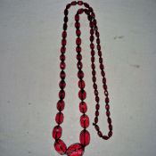 A faceted 'cherry amber' graduated long necklace, 20 ins.