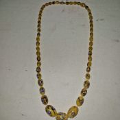 An old Venetian Murano string of graduated glass yellow beads with blue inclusions, 11" long.