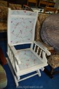 A white painted rocking chair decorated with bird fabric.