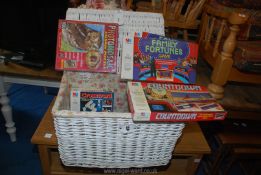 A wicker baskets full of family games and puzzles.