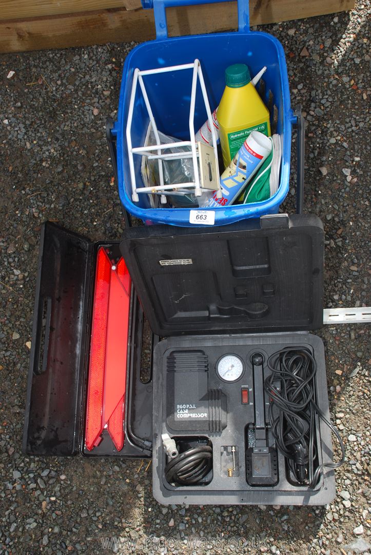 A blue waste bin and contents, air compressor and warning triangle.