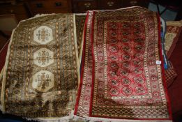 Four small rugs (2 pairs, in red and gold).