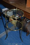 A two-tier brass and glass table, 30" high x 15" diameter.