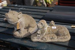 A concrete pig ornament and a family of dogs ornament.