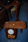 A small bench, plant stand and a clock.