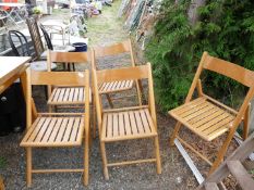 Five wooden folding chairs.