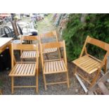 Five wooden folding chairs.