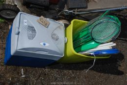 A cool box and a plastic bin of badminton equipment.