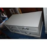 A low four drawer white unit 50" x 23½" x 23".