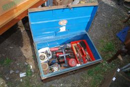 A metal trunk with contents, hand tools and foot pump.