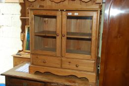 A glass fronted display cabinet with shelf and two drawers,